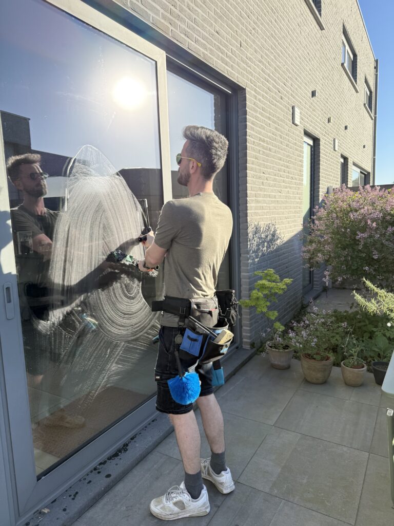 particulieren Ramenwasser die buiten een raam van een particulier huis schoonmaakt